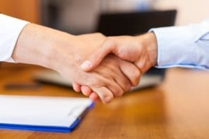personal injury lawyer shaking hands with new client
