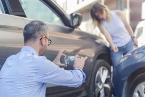 West Virginia Insurance Adjuster taking photos of car after crash