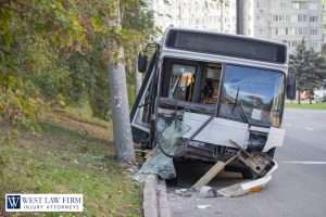 Damaged city bus after crashing into a pole, showing broken windshield and debris for a bus accident injury attorney claim